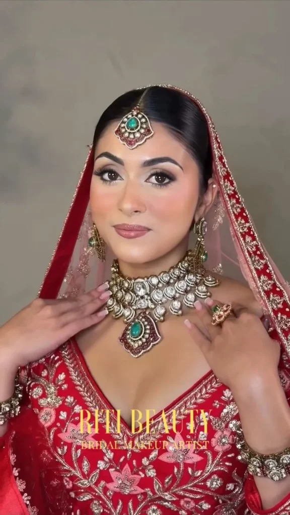 Luxury bride wearing a red lehenga with bridal makeup by Riti Beauty in Mumbai
